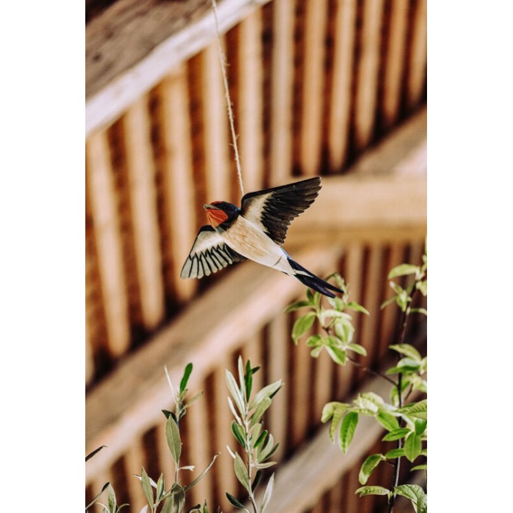 Hirondelle volante en bois sculpté