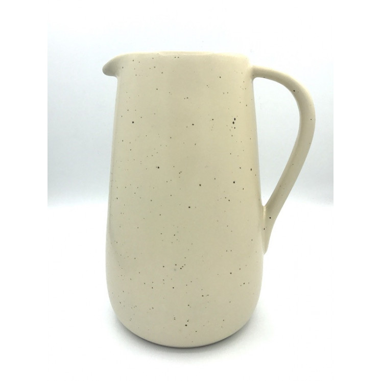Pichet en céramique de coloris blanc crème moucheté avec une finition émaillée mate.